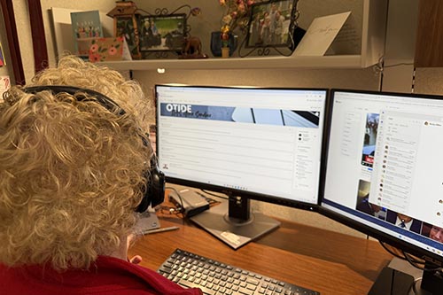 Person sitting at a desk wearing headphones using a computer